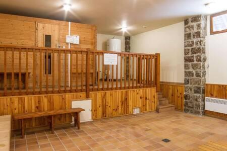 um quarto amplo com paredes de madeira e um banco de madeira em El racó de Montana em Enveitg