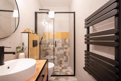 uma casa de banho com um chuveiro, um WC e um lavatório. em Downtown Delight: An Artsy and Homelike Haven em Budapeste