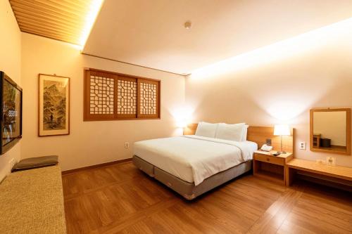 a bedroom with a large bed and a mirror at Sunbee Hotel Insadong Seoul in Seoul