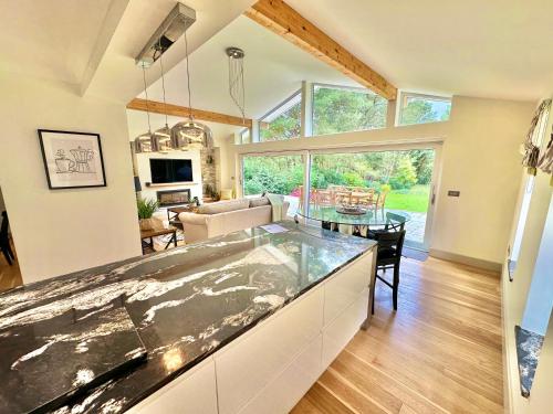 uma cozinha e sala de estar com uma grande bancada em Luxury Five Bed Home - Large Garden with BBQ - New Forest and Beach Links em Saint Leonards