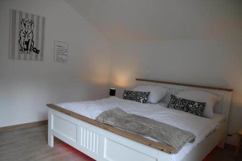 a bedroom with a bed with white sheets and pillows at Ferienhaus Neubau Tante Tilly in Langelsheim