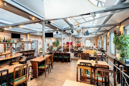 ein Restaurant mit Holztischen und -stühlen und einer Bar in der Unterkunft Welcome Kongress Hotel Bamberg in Bamberg