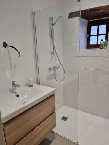 une salle de bain blanche avec un lavabo et une douche dans l'établissement Maison de la Plume, à Cajarc