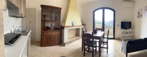 a kitchen and living room with a table and a fireplace at DoMu’ in Seùlo