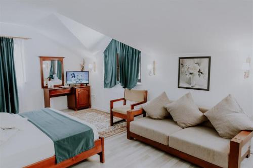 sala de estar con sofá y cama en Pensiunea Poiana Verde, en Slănic-Moldova