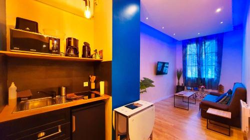 a kitchen and living room with blue and yellow walls at Le Chateau in Angers