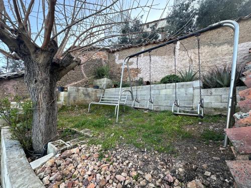 a swing in a yard next to a tree at Casa Patricia en Fuencaliente con Piscina privada Climatizada in Fuencaliente