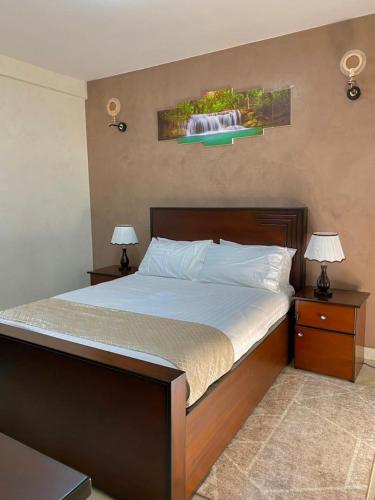 um quarto com uma cama grande e 2 mesas de cabeceira em Peacock unit30 em Kampala