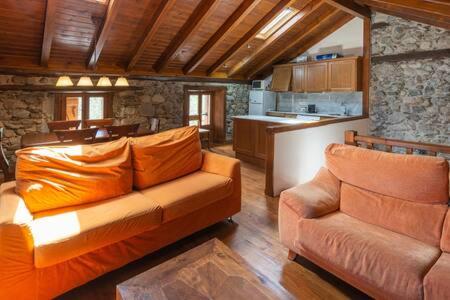 un salon avec un canapé et une cuisine dans l'établissement El Dúplex del Riu Carol, à Latour-de-Carol