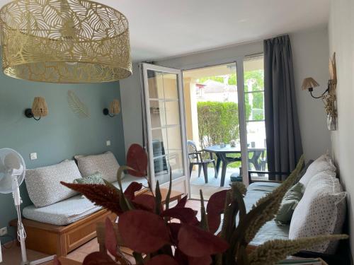ein Wohnzimmer mit einem Sofa und einem Tisch in der Unterkunft Charmant T2 chambre lit double dans résidence du Lac in Monflanquin