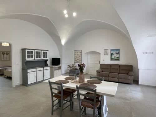 cocina y sala de estar con mesa y sillas en Masseria Don Sante, en Fasano