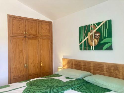 1 dormitorio con 1 cama y una pintura en la pared en Apartamento El Islote direct at Paradise Beach, en Cotillo