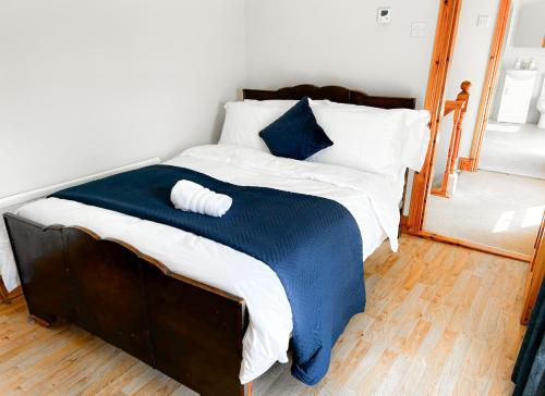 a bed with a blue and white comforter and a mirror at Lisheenbawn Farmhouse Farranfore in Farranfore