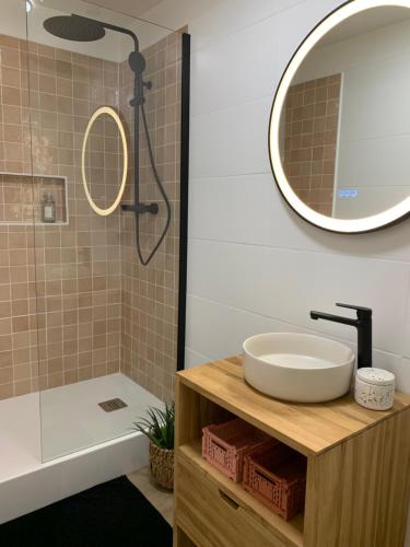 La salle de bains est pourvue d'un lavabo et d'une douche avec un miroir. dans l'établissement Gîte Les Mijoteurs, à Rocamadour