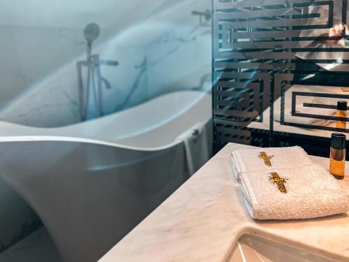 ein Badezimmer mit einer Badewanne, einem Handtuch und einem Waschbecken in der Unterkunft Anahita Boutique Hotel in Málaga