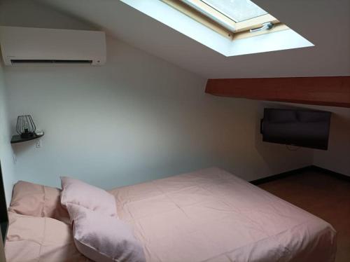 a bedroom with a white bed and a skylight at Appartement Caraman in Caraman