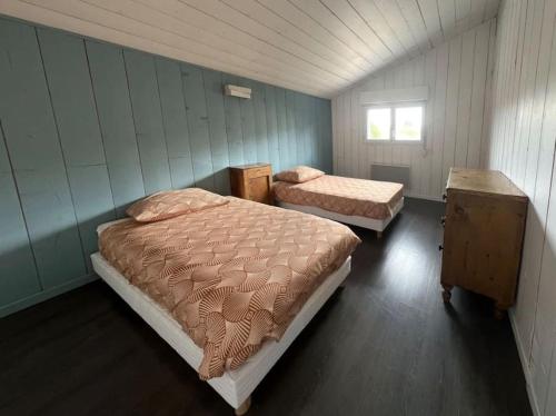 une chambre avec deux lits et une fenêtre dans l'établissement Villa avec piscine proche du lac, à La Teste-de-Buch