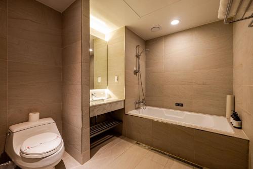 a bathroom with a toilet and a bath tub at Hotel Sunbee Insadong in Seoul