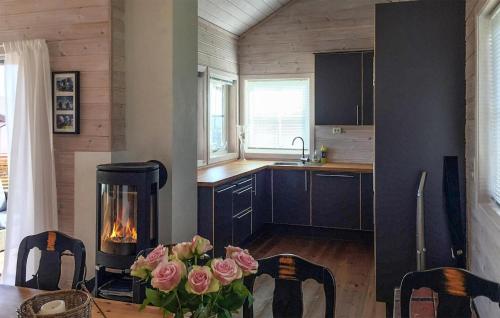 a kitchen with a fireplace and a table with roses at Stunning Home In Bvgen With House Sea View in Bøvågen