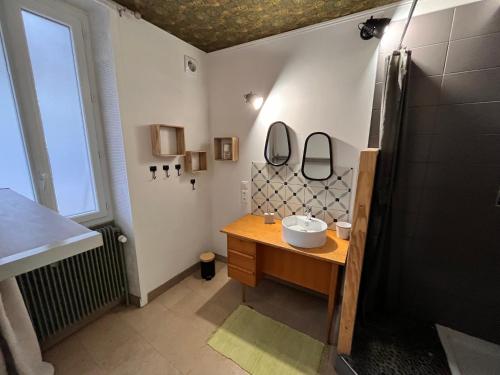 une salle de bain avec un lavabo et deux miroirs au mur dans l'établissement Charmante maison, à Auxerre