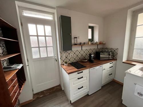 une cuisine avec des armoires blanches et un comptoir dans l'établissement Charmante maison, à Auxerre