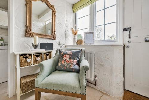 a living room with a chair and a mirror at Live the coastal cottage dream in Dorset AONB in Weymouth
