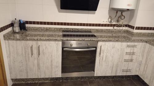 a kitchen with a counter top with a stove top oven at Fondás in Foz