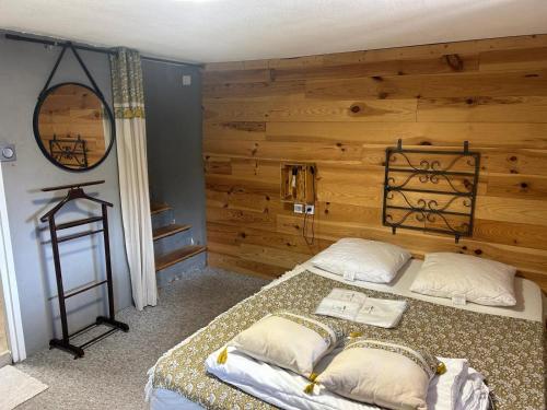 a bedroom with two beds and a wooden wall at Les 3 Flocons Roure in Roure
