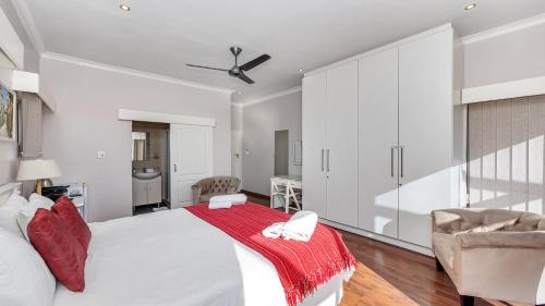 a bedroom with a large bed with a red blanket on it at Anchor Bay Workation in Cape Town