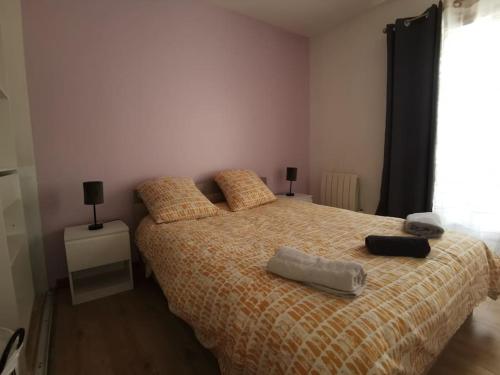 een slaapkamer met een bed met een geel dekbed bij n1 F2 40m2 avec petit jardin in Hérouville-Saint-Clair