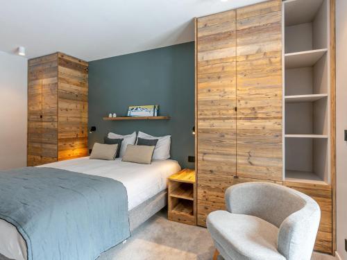 une chambre avec un lit et une chaise dans l'établissement Bel appartement 3 pièces avec wifi, garage et terrasse, pied des pistes, résidence neuve à Val-d'Isère - FR-1-694-331, à Val dʼIsère