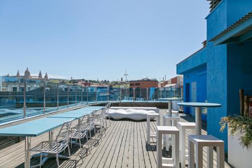 a deck with tables and chairs on a building at Hotel Acta Azul Barcelona in Barcelona