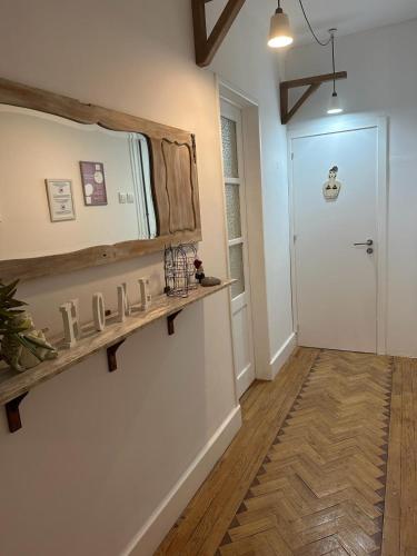 a hallway with a mirror on the wall and a door at Alojamentos Vista Mar-Luisa Todi in Setúbal