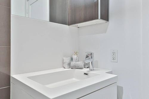 a bathroom with a white sink and a mirror at New 3 BR with Free parking Downtown Toronto in Toronto