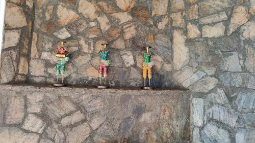 a group of three figurines on a stone wall at Adaara Retreat - Pet Friendly Cottages, Almora in Almora