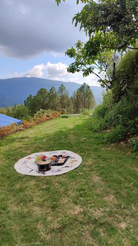 a grill on the ground in the grass in a field at Adaara Retreat - Pet Friendly Cottages, Almora in Almora