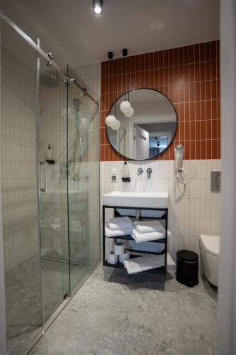 a bathroom with a shower and a sink and a mirror at Ołowianka B&B in Gdańsk