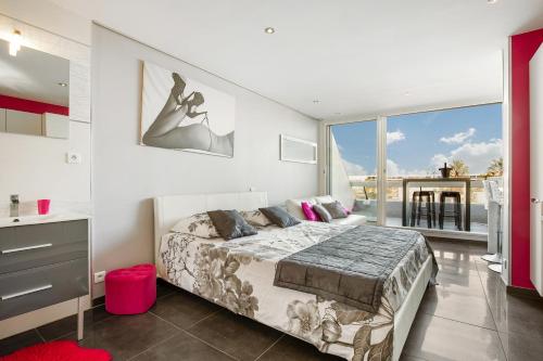 une chambre avec un lit et une grande fenêtre dans l'établissement Full Moon Heliopolis, au Cap d'Agde