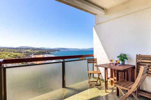 d'un balcon avec une table et des chaises et une vue sur l'océan. dans l'établissement Primera línea de playa Surf & Beach, à Sopelana