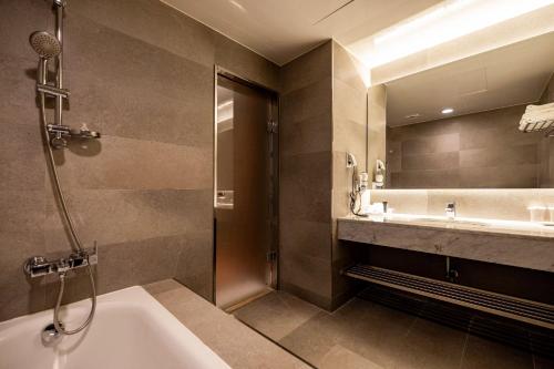 a bathroom with a tub and a sink and a shower at Sunbee Hotel Insadong Seoul in Seoul