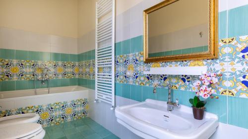 y baño con lavabo, aseo y espejo. en VILLA TREGGIAIA 12&2, Emma Villas, en San Casciano in Val di Pesa