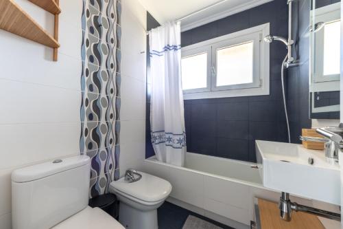 a bathroom with a white toilet and a sink at Primera línea de playa Surf & Beach in Sopelana