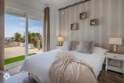 ベニタチェルにあるVilla Punta Vista 6 by Abahana Luxeのベッドルーム(白いベッド1台、大きな窓付)