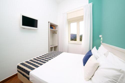 a white bedroom with a bed and a window at Hotel Royal Hills in Piano di Sorrento
