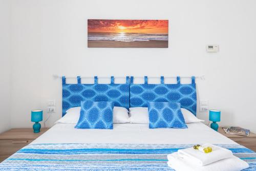 - une chambre dotée d'un lit bleu et blanc avec une photo sur le mur dans l'établissement La conchiglia dei sogni - YourPlace Abruzzo, à Rocca San Giovanni