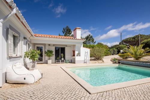 a villa with a swimming pool in front of a house at Seashore Escape in Aljezur