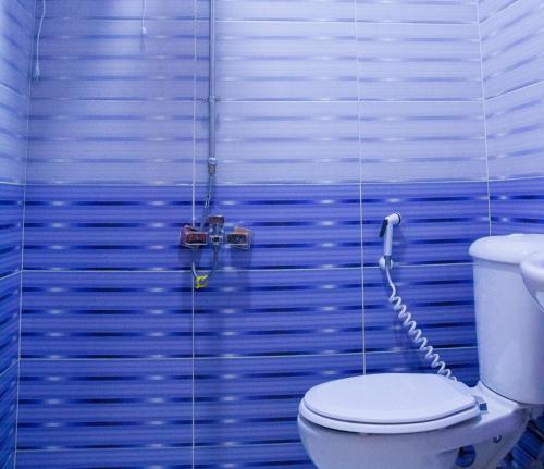 a bathroom with a toilet and a shower with blue walls at ستديو مفروش - غرفة فندقيه - للايجار Studios - Room in 6th Of October