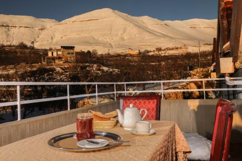 a table on a balcony with a view of a mountain at Samar Resort in Bcharré