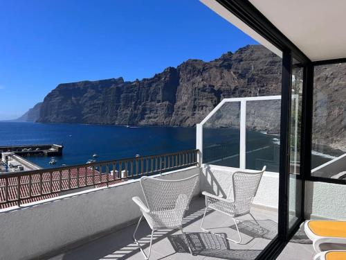 Un balcón con sillas y vistas al océano. en Stunning cliffs and ocean view in Los Gigantes en Acantilado de los Gigantes