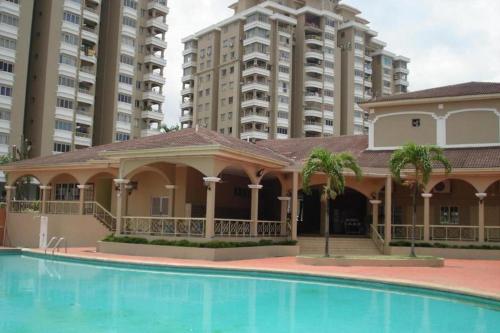 シャー・アラムにあるFarahuna Houseの高層ビルの前にスイミングプールを併設するホテル